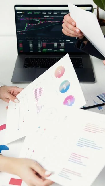 Focused business analysis with charts and graphs on a laptop in a modern office setting.